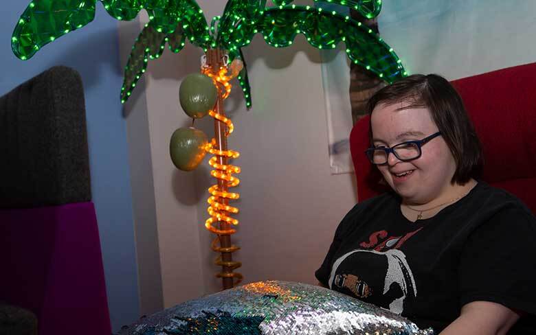 Young woman in a sensory room designed for individuals with autism and other developmental disabilities.