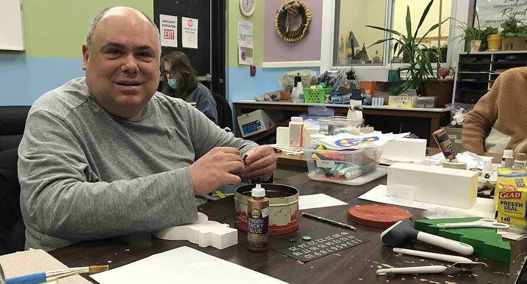 Man in the Washington Day Program at Abilities of Northwest Jersey making holiday decorations