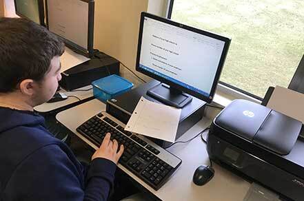 High school student with special needs working on computer at Abilities youth in transition service