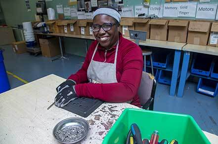 Woman working on electronics recycling for Sustainabilities community and business service