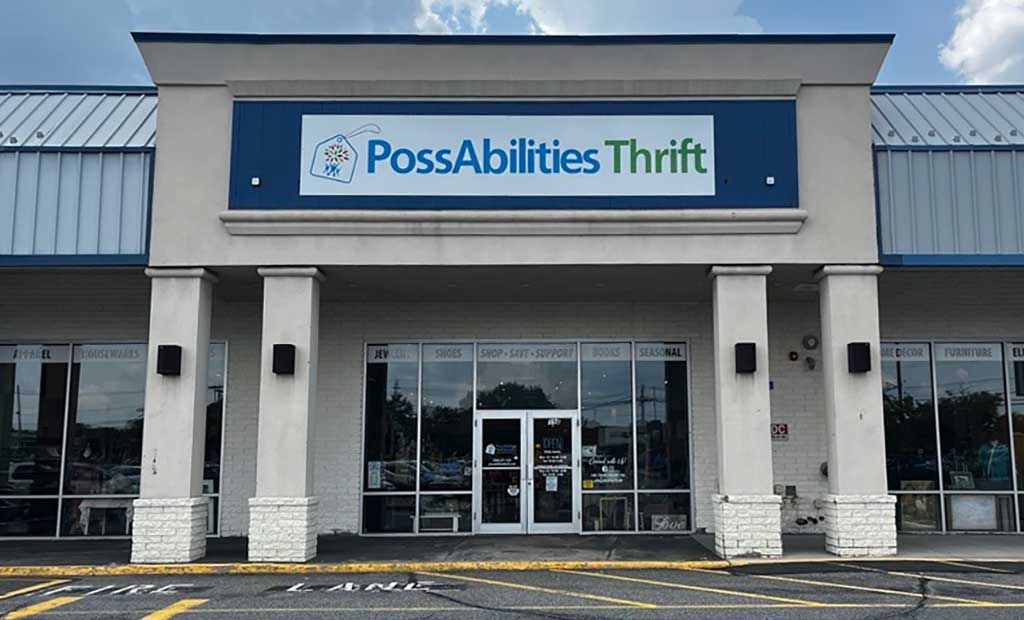 Exterior entrance of PossAbilities Thrift, a retail thrift store in a shopping center, featuring a large PossAbilities Thrift sign above glass entry doors and storefront windows.